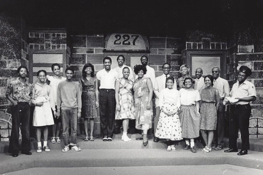 Black-and-white photograph of the original 227 stage play cast assembled on the tenement stoop set beneath the number 227.